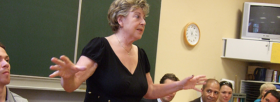 Marjan, Arme ausgestreckt vor Schulklasse