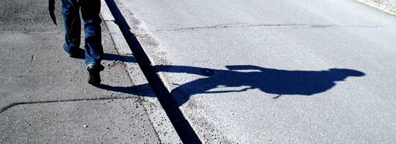 Abduls Schatten auf dem Asphalt